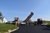 Kozakowice, ul. Biała, układanie pierwszej warstwy asfaltu