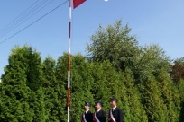 Poczet sztandarowy przy maszcie z flagą państwową