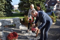 Przewodniczący Rady Gminy Karol Lipowczan, Wójt Sylwia Cieślar oraz Zastępca Przewodniczącego Rady Elżbieta Duraj składają kwiaty i znicz pod pomnikiem