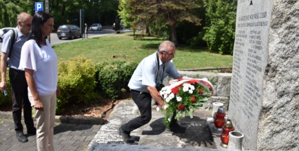 Składnie kwiatów pod pomnikiem znajdującym się przed wejściem do urzędu